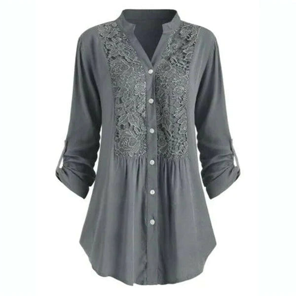 Grijze damesblouse met pofmouwen en knoopsluiting, voorzien van elegante kantdetails. Perfect voor casual en formele gelegenheden.