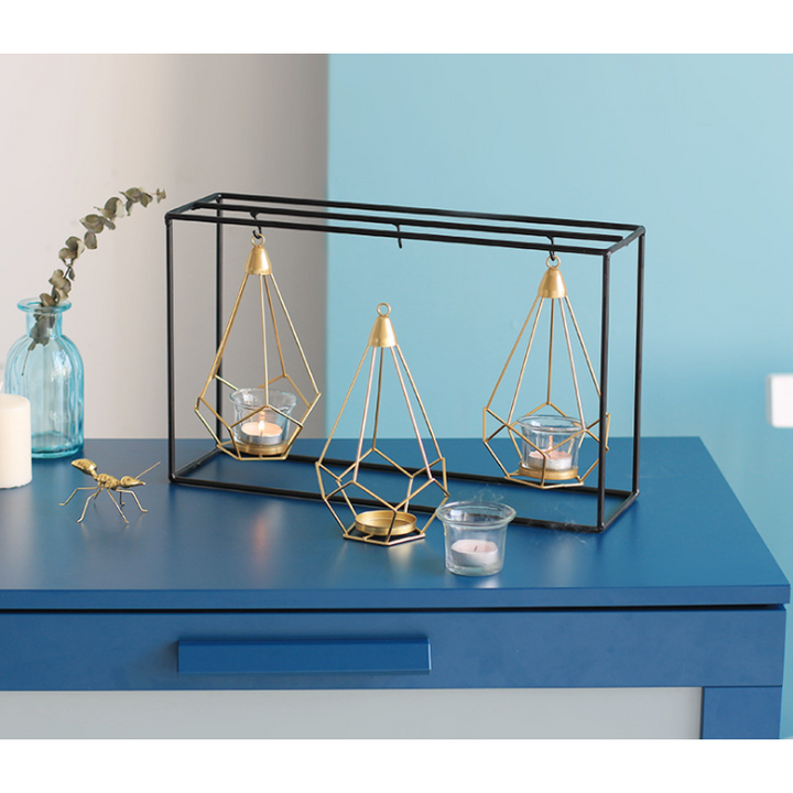 Kandelaar en theelichthouder met modern geometrisch metalen frame en gouden draadkooien