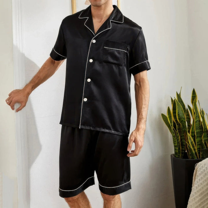https://cdn.shopify.com/s/files/1/0659/5451/2986/files/korte-heren-pyjama-set-blauw-en-zwart-met-button-down-overhemd-en-korte-broek-ideale-zomernacht-kled-2.jpg?v=1753541895