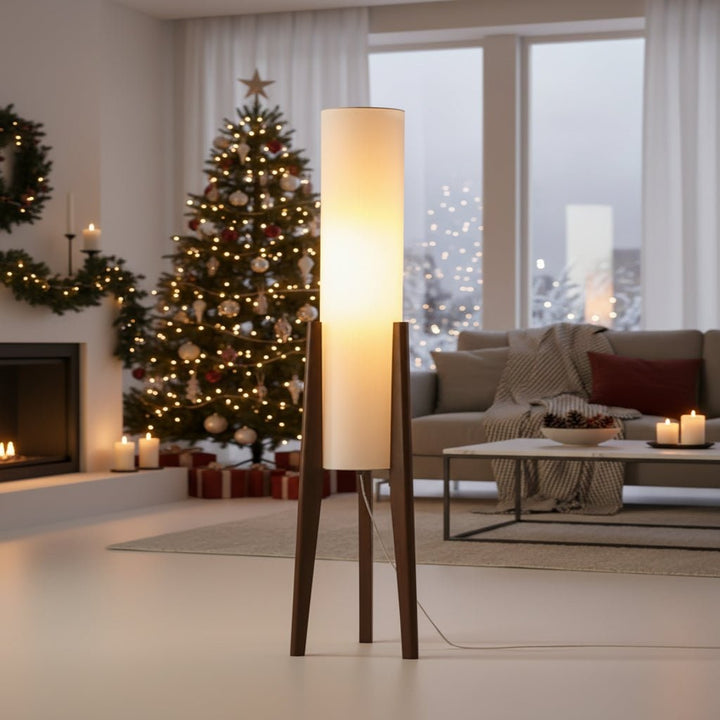Hoge LED-vloerlamp met houten driepoot en cilindrische stoffen kap met tafel