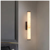 Moderne wandlamp met marmeren cilinderkap en opbouw messingafwerking, minimalistisch