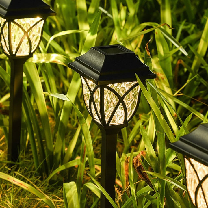 Zonne-energie padverlichting voor de tuin buiten met craquelé glazen lens en geïntegreerd paneel op prikker